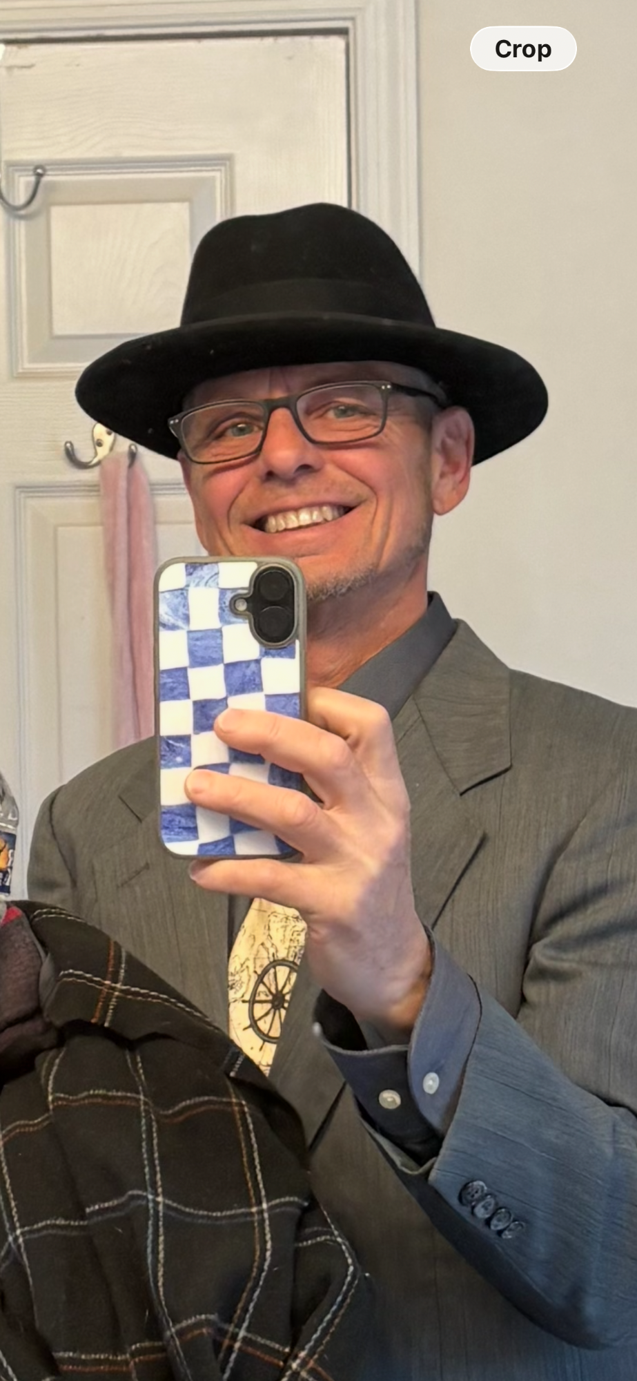 Joseph A. Webb smiling in a dark hat, glasses, and gray suit jacket